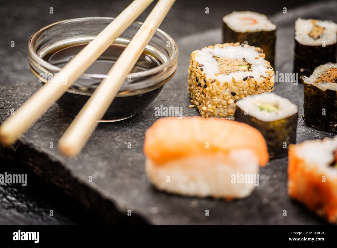 Traditional japanese sushi rolls hosomaki,uramaki, nigiri  and chopsticks and soy sauce on stone desk Stock Photo