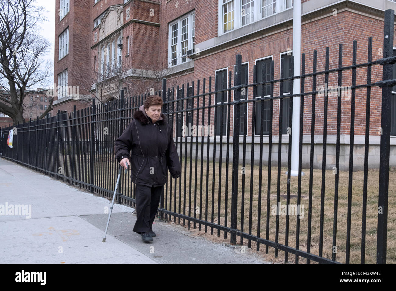 An older Hispanic woman walks alone with the aid of a cane. On 37th Avernue on Jackson Heights Queens, New York. Stock Photo