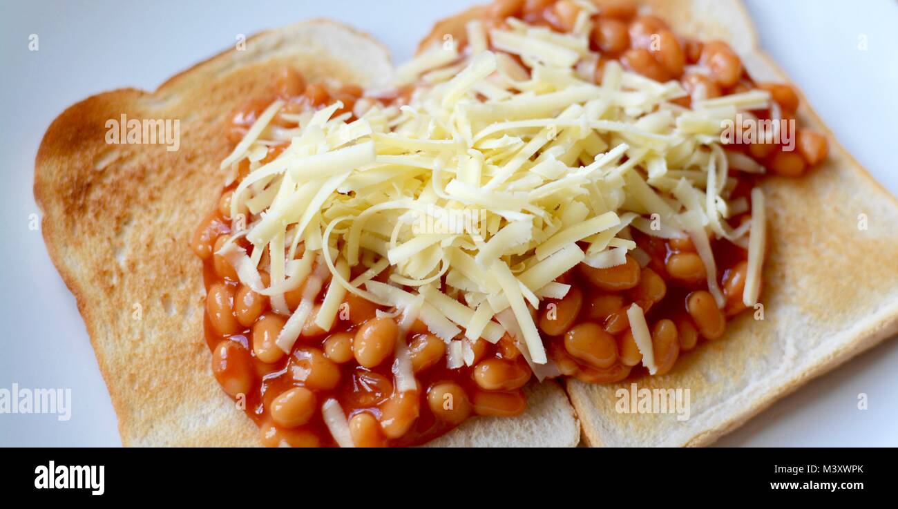 Baked beans on white toast topped with grated cheddar cheese Stock