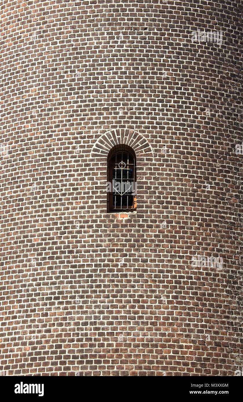 Brick wall with the window. Trellis with anchor shape. Stock Photo