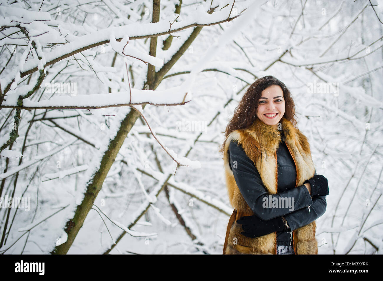 Elegance curly girl in fur coat at snowy forest park at winter Stock ...