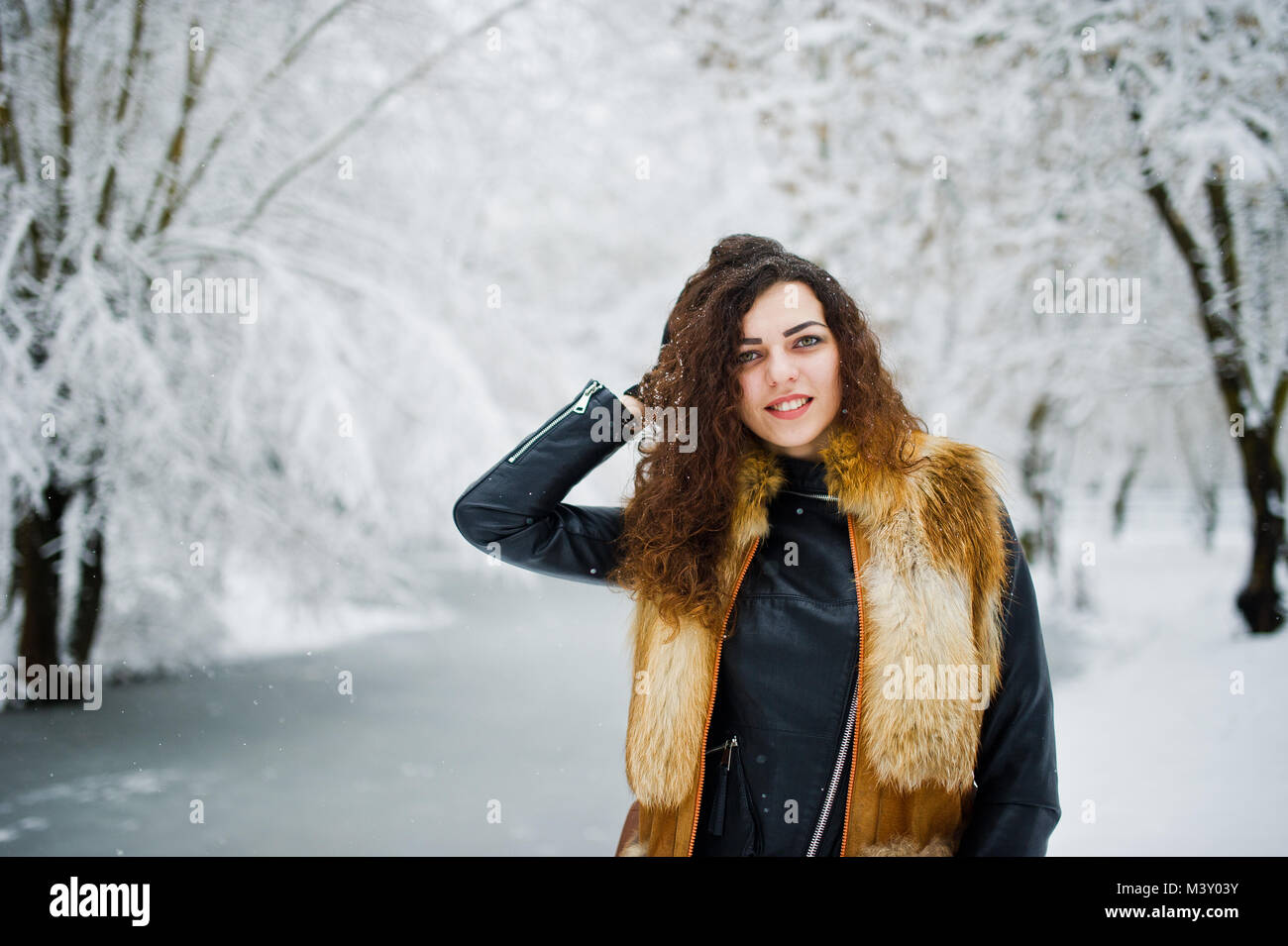 Elegance curly girl in fur coat at snowy forest park at winter Stock ...