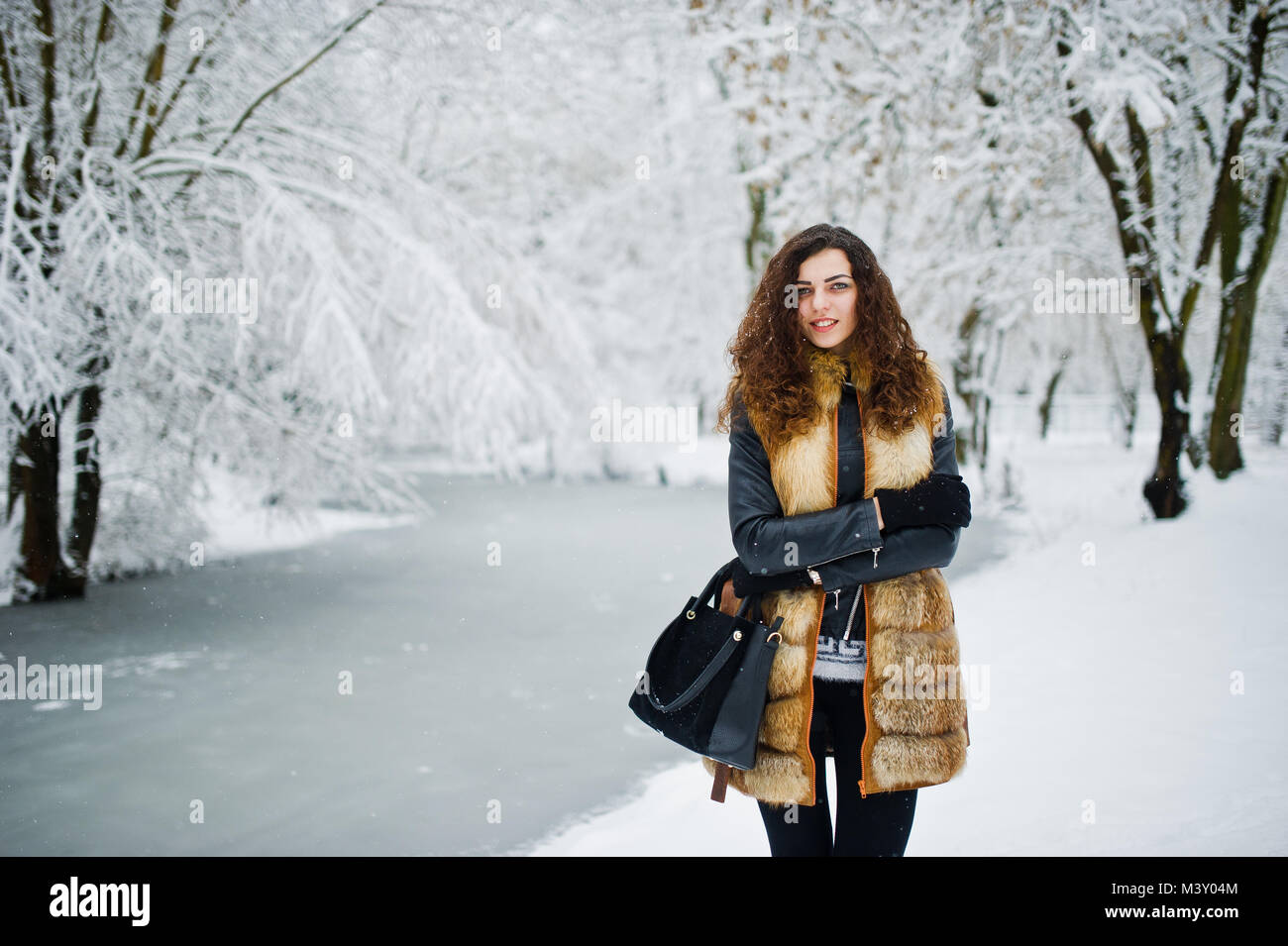 Elegance curly girl in fur coat at snowy forest park at winter Stock ...
