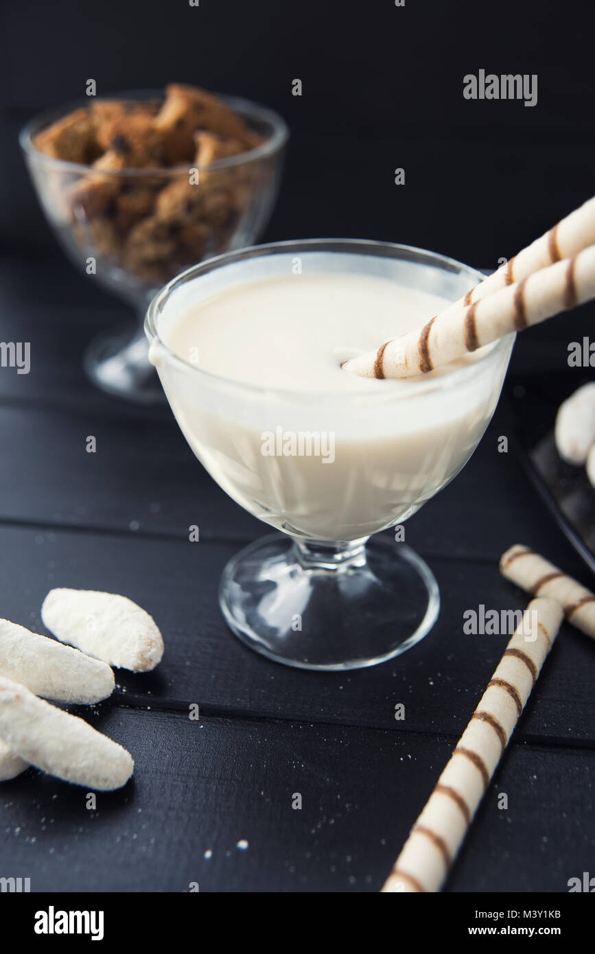sweets, straws in the cream, cookies and candies on the table Stock Photo