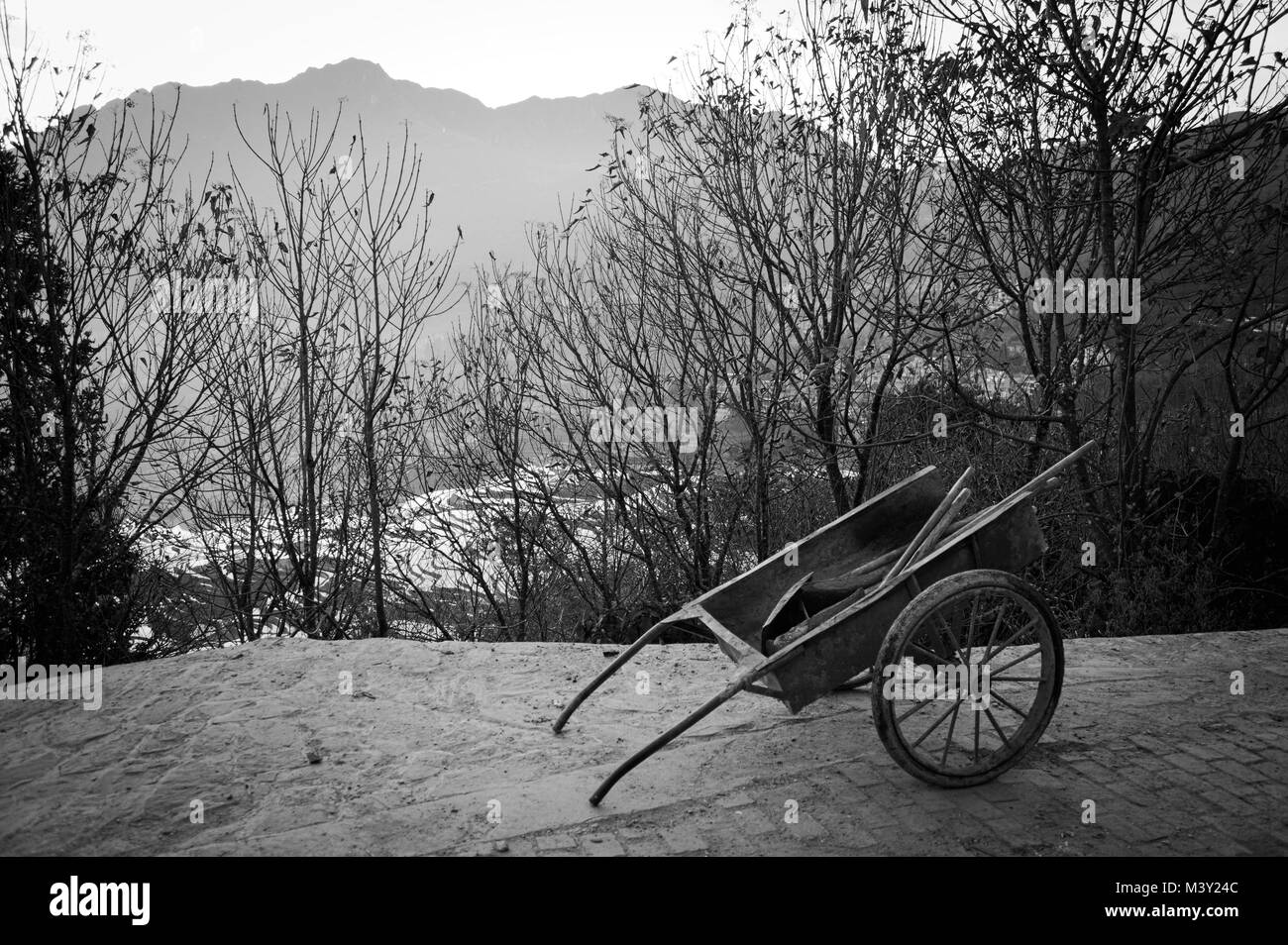 Isolated wheelbarrow on the street (Yunnan, China) Stock Photo