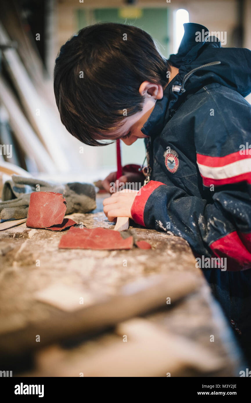 10yearold boy in a carpenter's learns to do small jobs