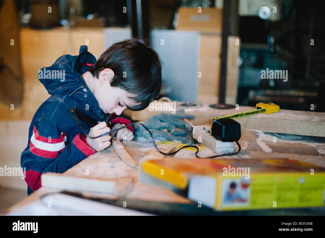 10yearold boy in a carpenter's learns to do small jobs