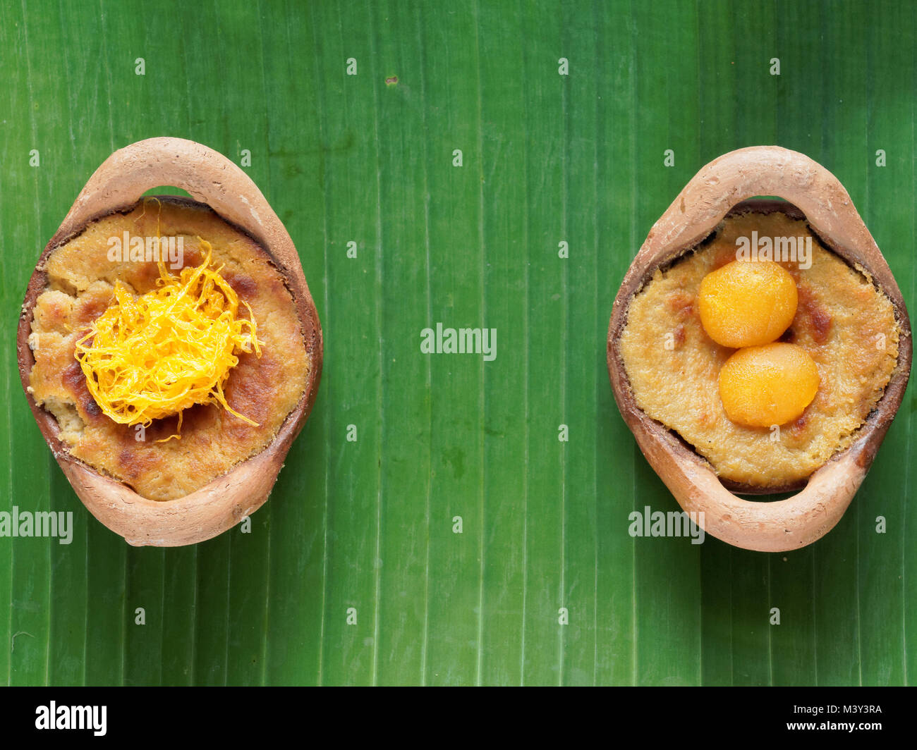 Thai coconut custard pudding dessert, Maw Gaeng, in clay pot on banana leaf background Stock Photo