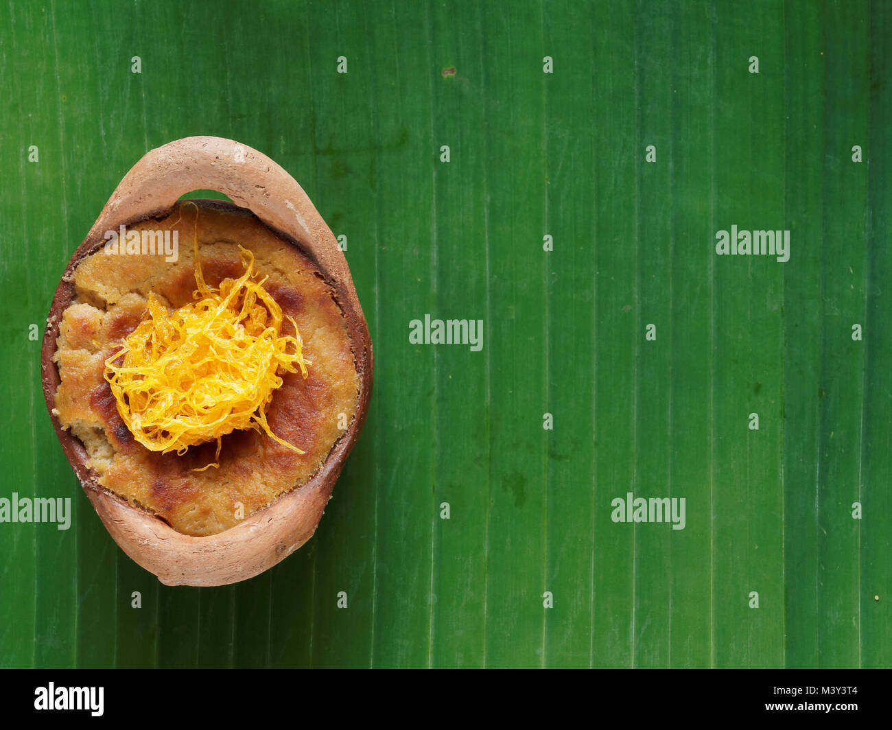 Thai coconut custard pudding dessert, Maw Gaeng, in clay pot on banana leaf background Stock Photo