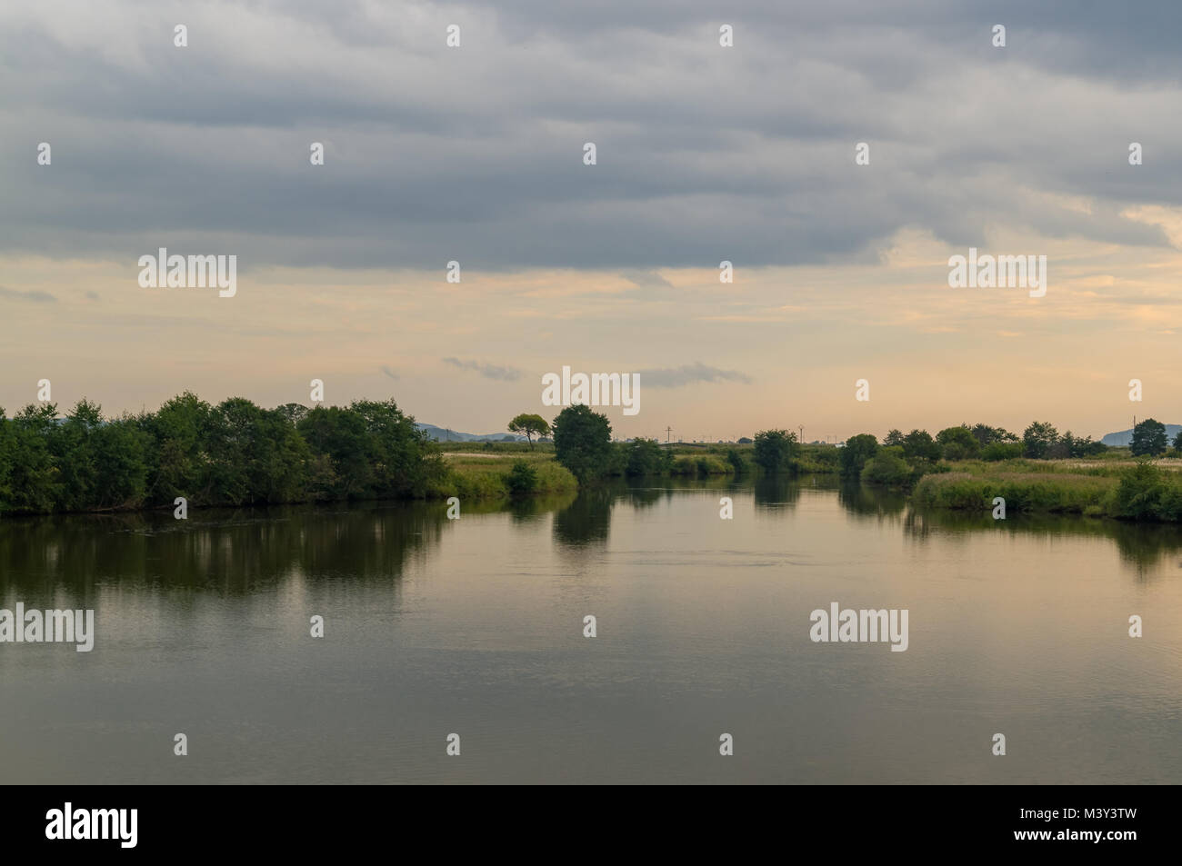 Calming scene on the river. In the evening, clouds over the river. Two shore Stock Photo