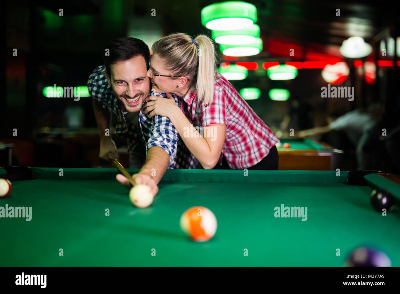 Young couple playing snooker together in bar Stock Photo