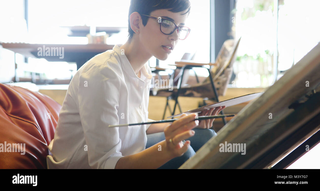 Female artist painting with palette and paintbrush Stock Photo - Alamy