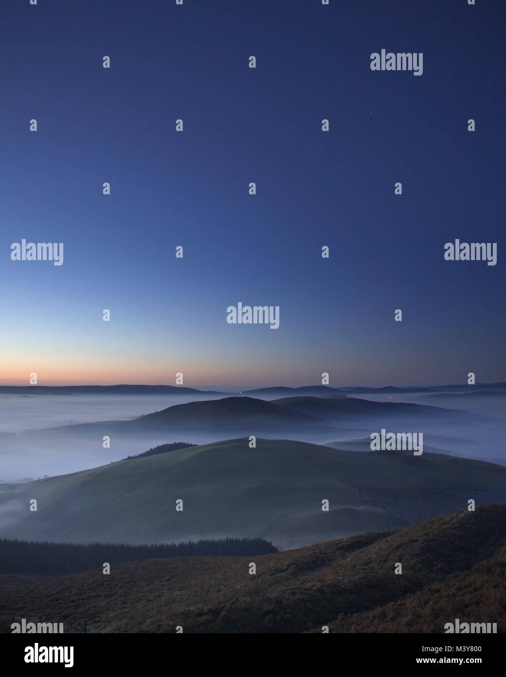 Clwydian mountains in mist at dawn under a clear sky Stock Photo