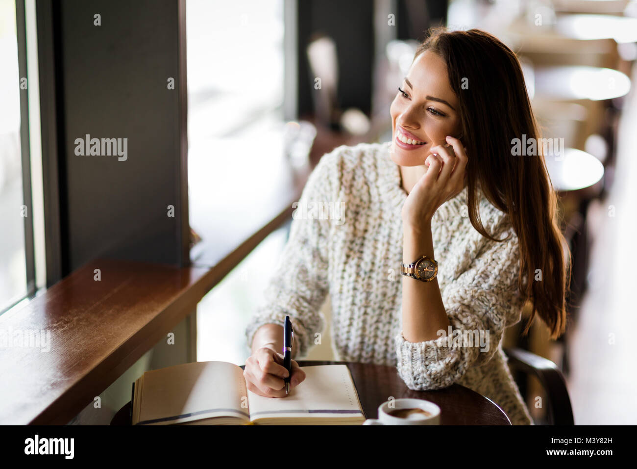 Portrait of happy young woman in cafe Stock Photo - Alamy