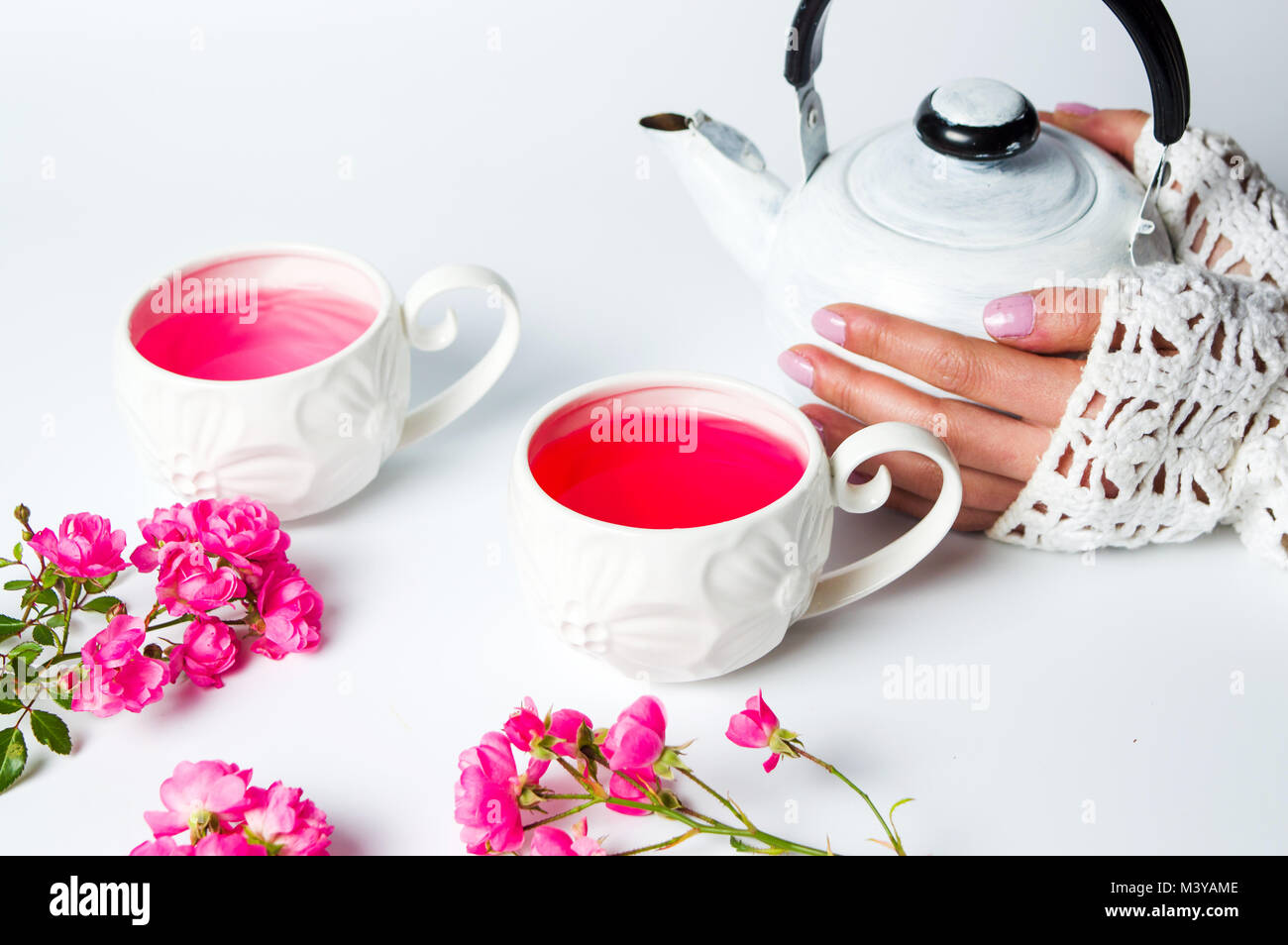 Female hands on a teapot. Rose tea time Stock Photo