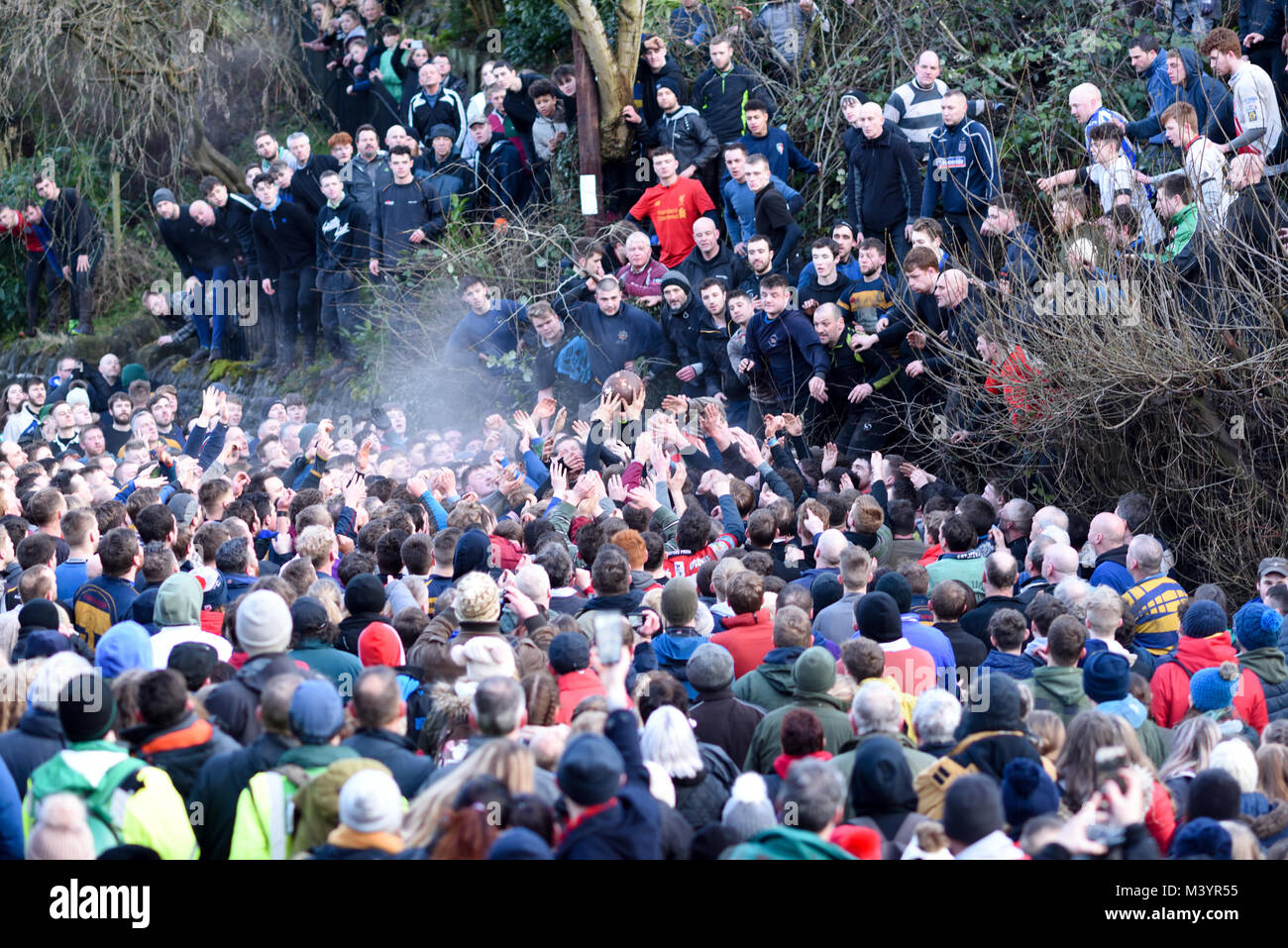 Ashbourne, Derbyshire, UK:13th February 2018: Shrove Tuesday and the first day of royal Shrovetide football in the market town of Ashbourne.Thousand turning out in the driving rain to watch the up'ards and down'ards do battle for the ball.The game started at 14.00hrs and can go on until 22.00hrs tonight unless a ball is goaled after 1700hrs.Then they do it all again tomorrow. Credit: Ian Francis/Alamy Live News Stock Photo