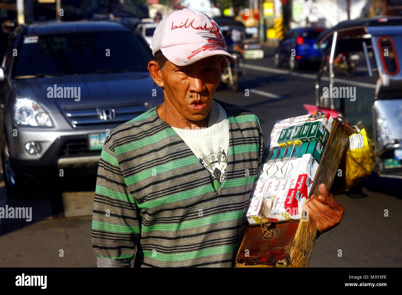 cigarette vendor ANTIPOLO CITY, PHILIPPINES - FEBRUARY 3, 2018: A cigarette vendor peddles  his product in the streets of Antipolo City, Philippines Stock Photo