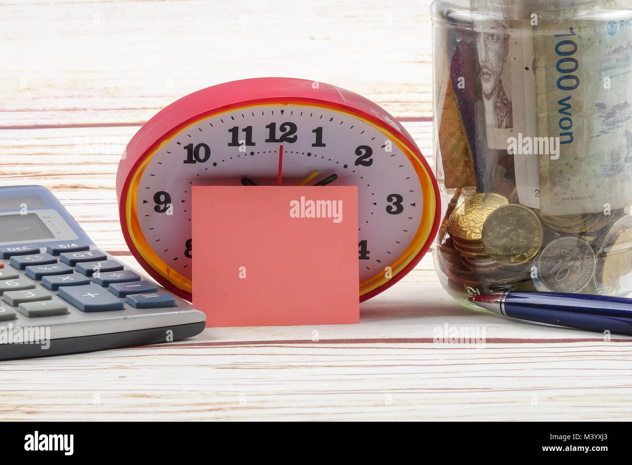 TAX DAY CONCEPT; Clock,red note,calculator and coins in the mason jar over wooden background. Stock Photo