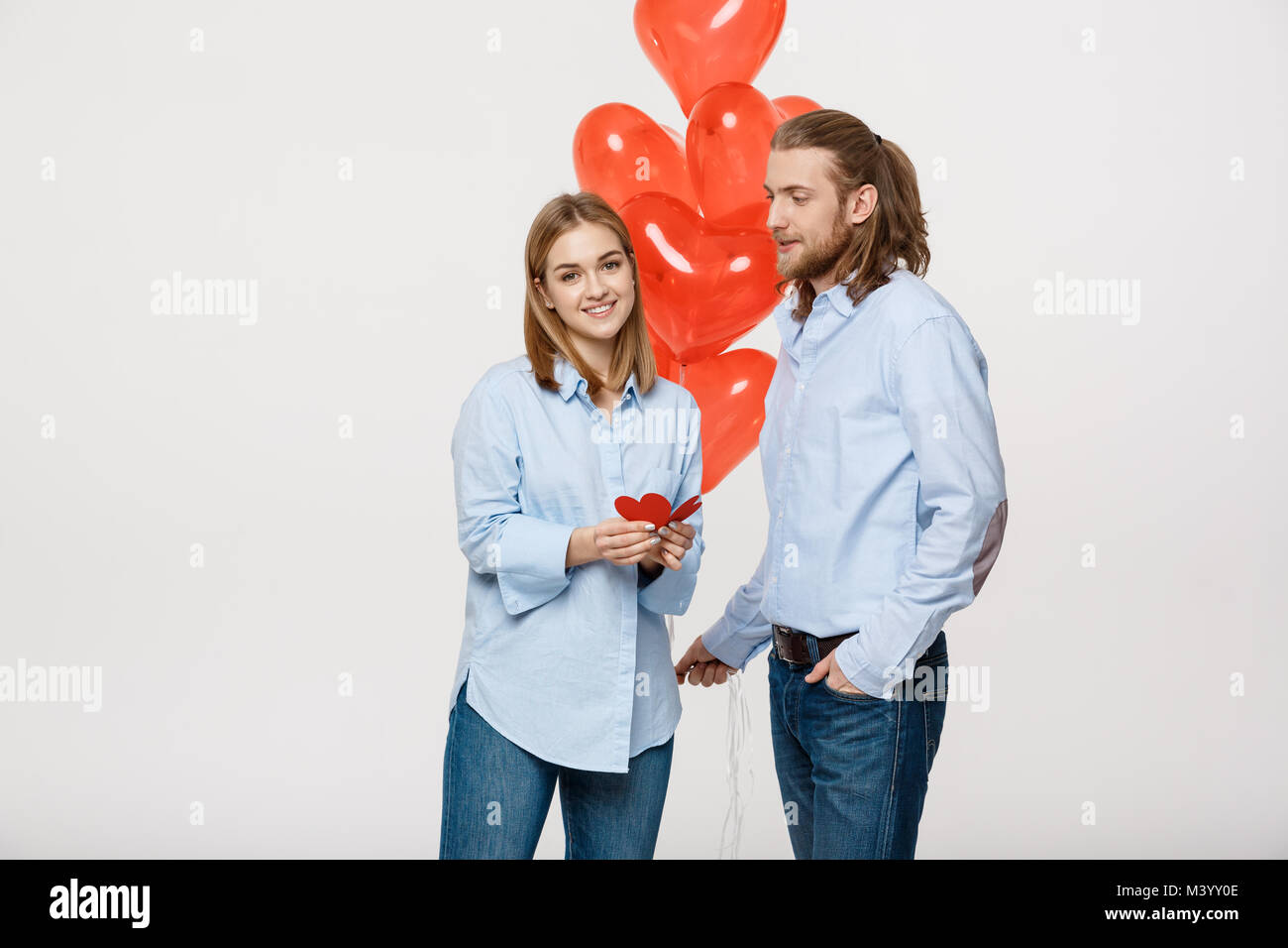 Young attactive caucasian couple holding heart balloon and paper Stock ...
