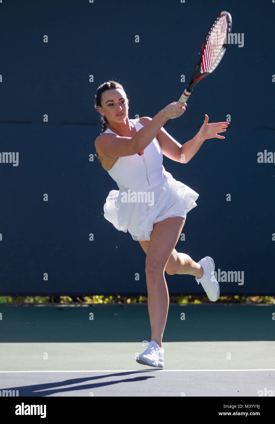 A young woman tennis player hits a forehand on a tennis court in Beverly  Hills, California. Photo by Francis Specker Stock Photo - Alamy