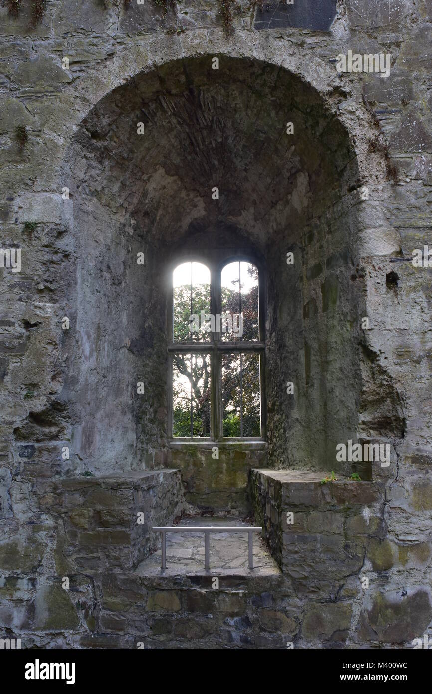 Window with wall seat in thick wall of stone caste ruin in Maynooth in Ireland. Stock Photo