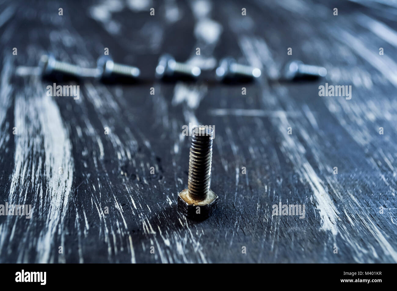 Nuts for repairs lying on a wooden table. Iron nuts and screws f Stock Photo