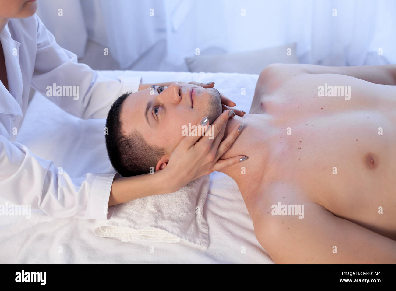 male masseuse makes a therapeutic massage in the Spa Stock Photo