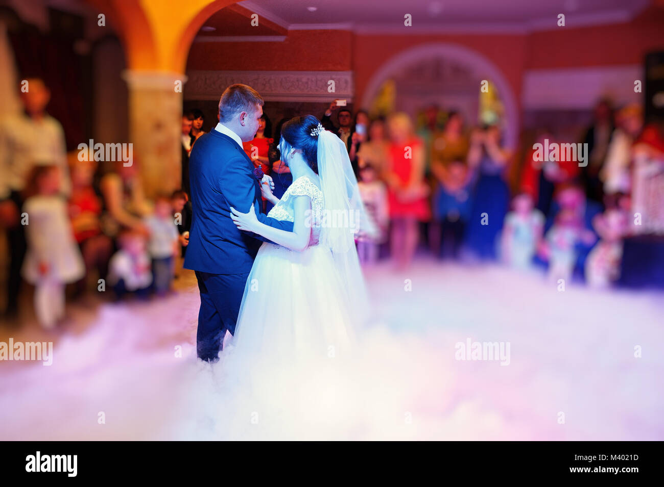 Happy young wedding couple dancing their first dance with different ...