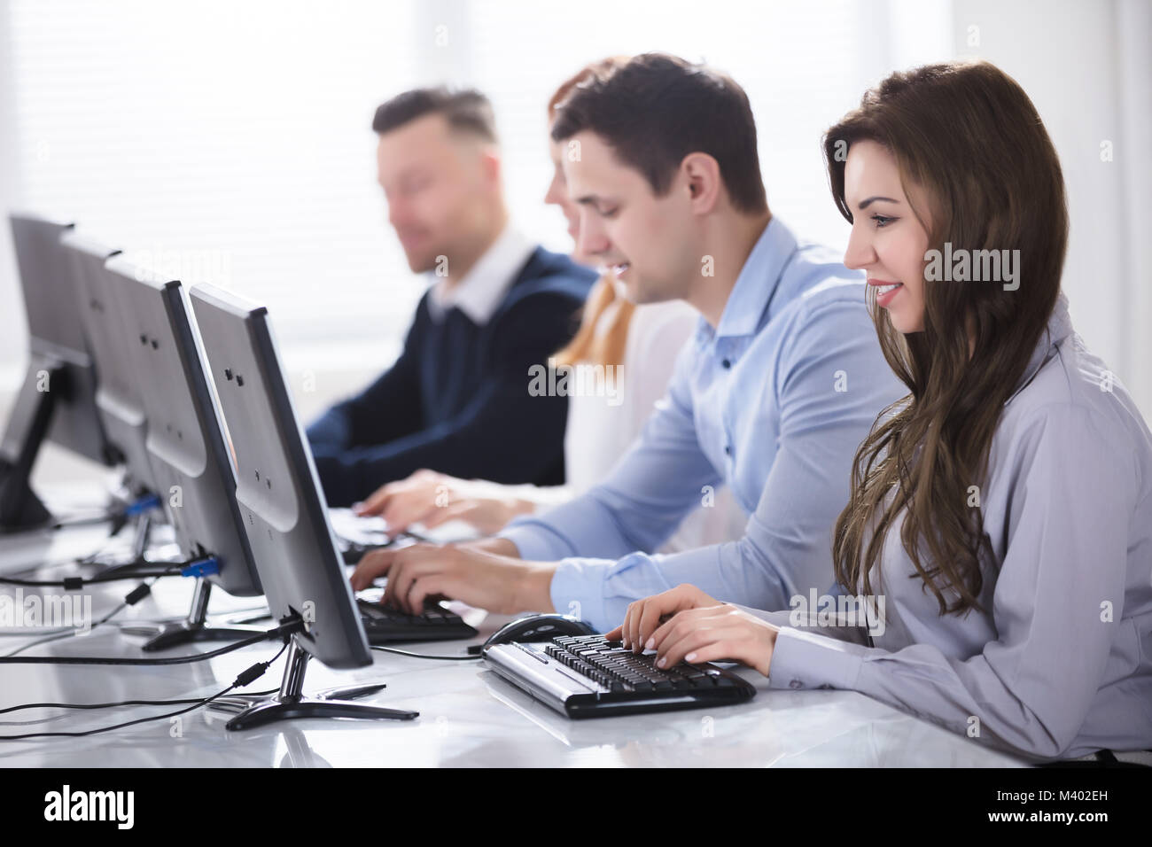 Young Business People Using Computer At Workplace In Office Stock Photo ...