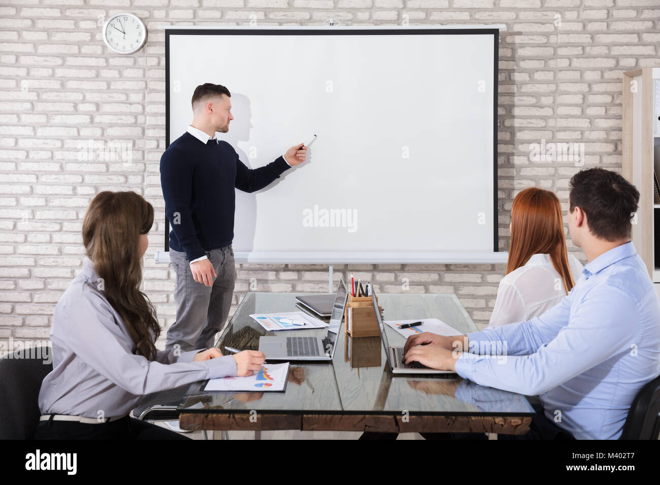 Businessman Giving Presentation To His Colleagues In Business Meeting ...