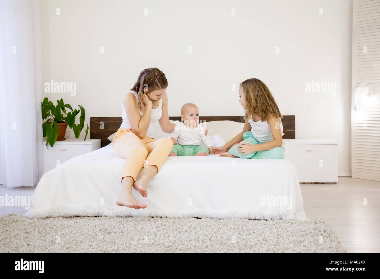 three girls sisters in the morning in the bedroom 1 Stock Photo