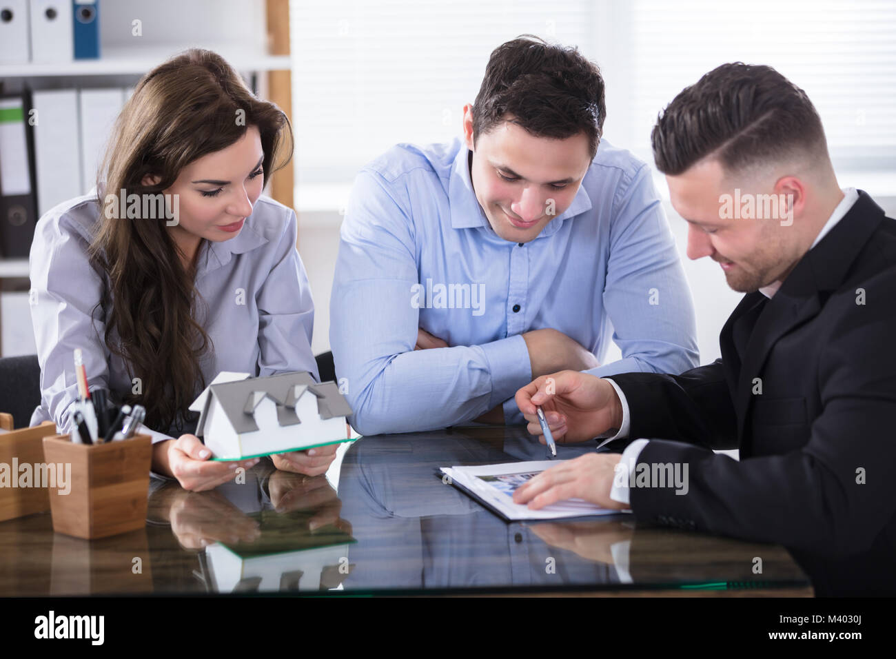 Couple Planning New House Project With Architect At Office Stock Photo