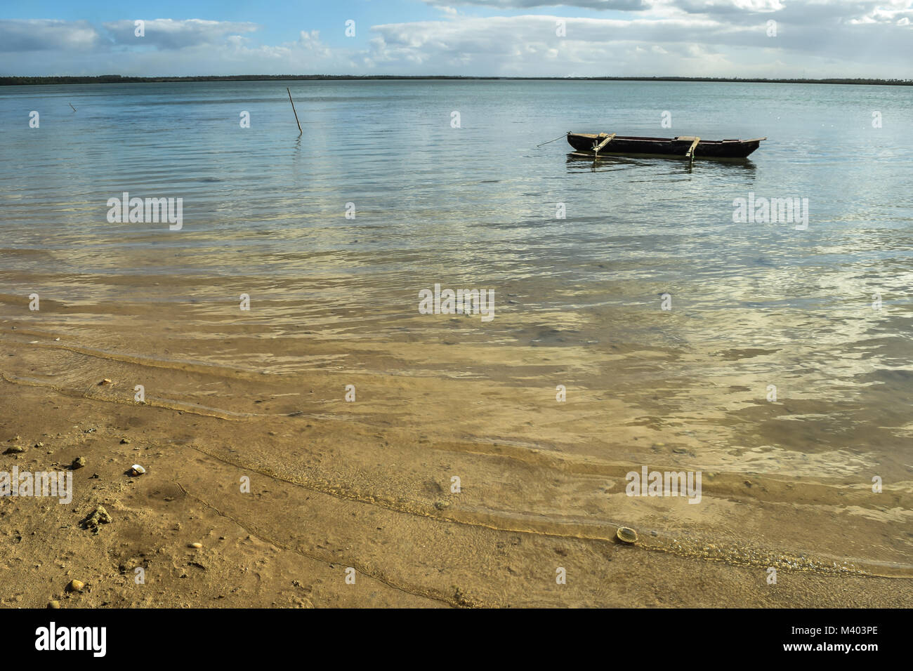 Traditional fishing boat sitting on calm clear water, Tongatapu, Tonga Stock Photo