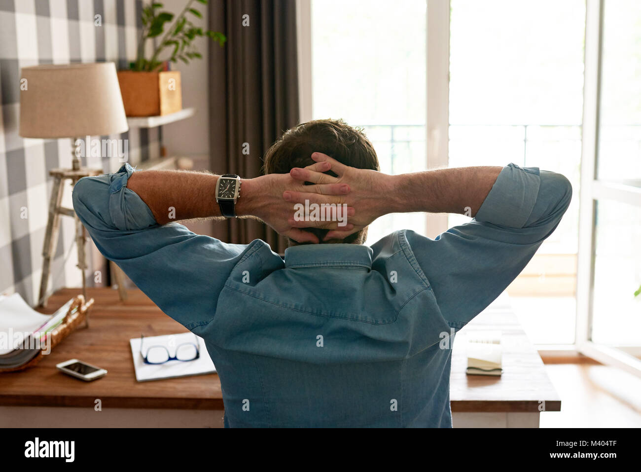 Man leaning back in his chair while working from home Stock Photo Alamy