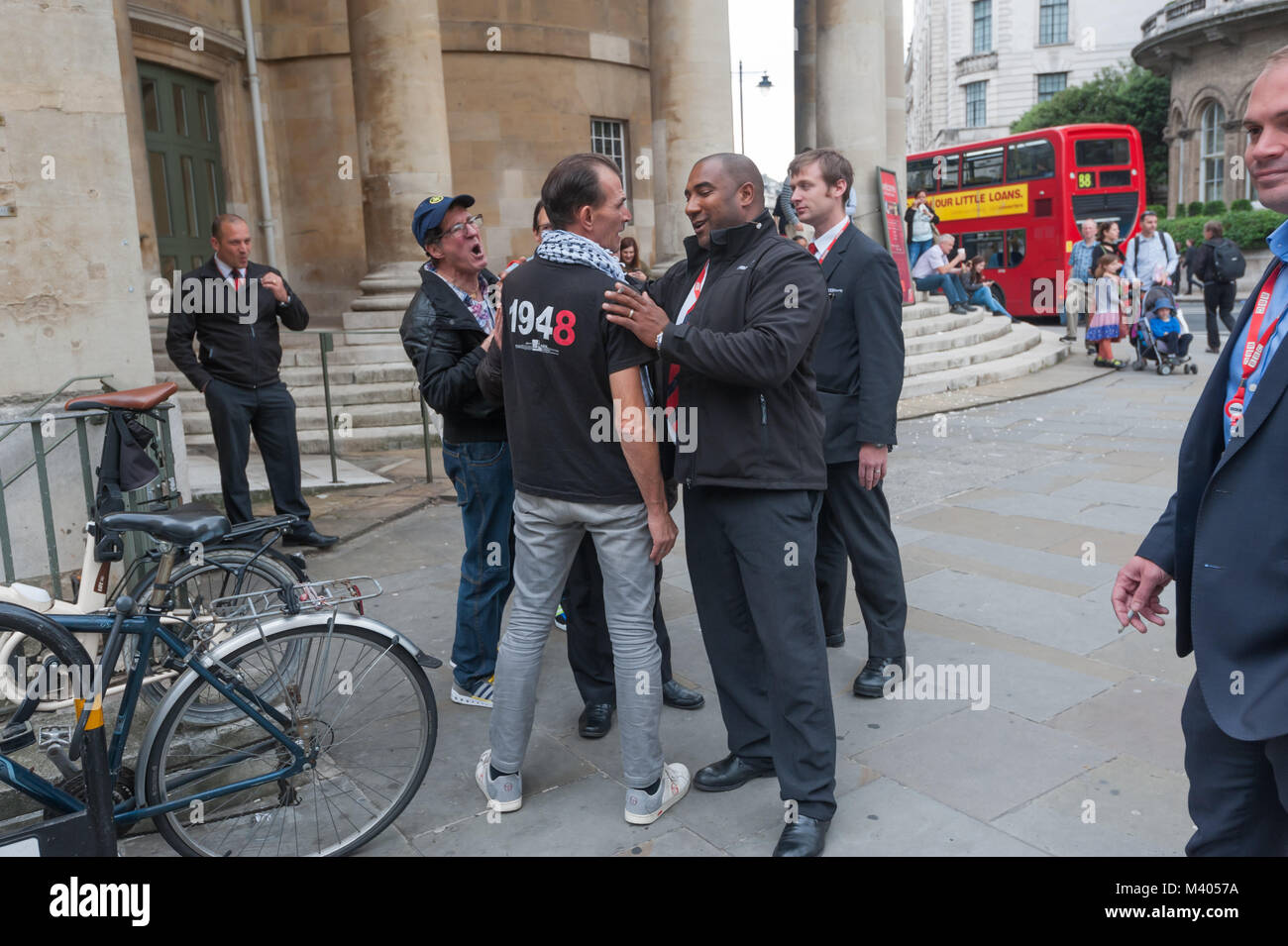Security outside the BBC try to calm a man who argued with protesters calling on the BBC to report fairly about the illegal detention of Palestinians including the two hunger strikers. Stock Photo