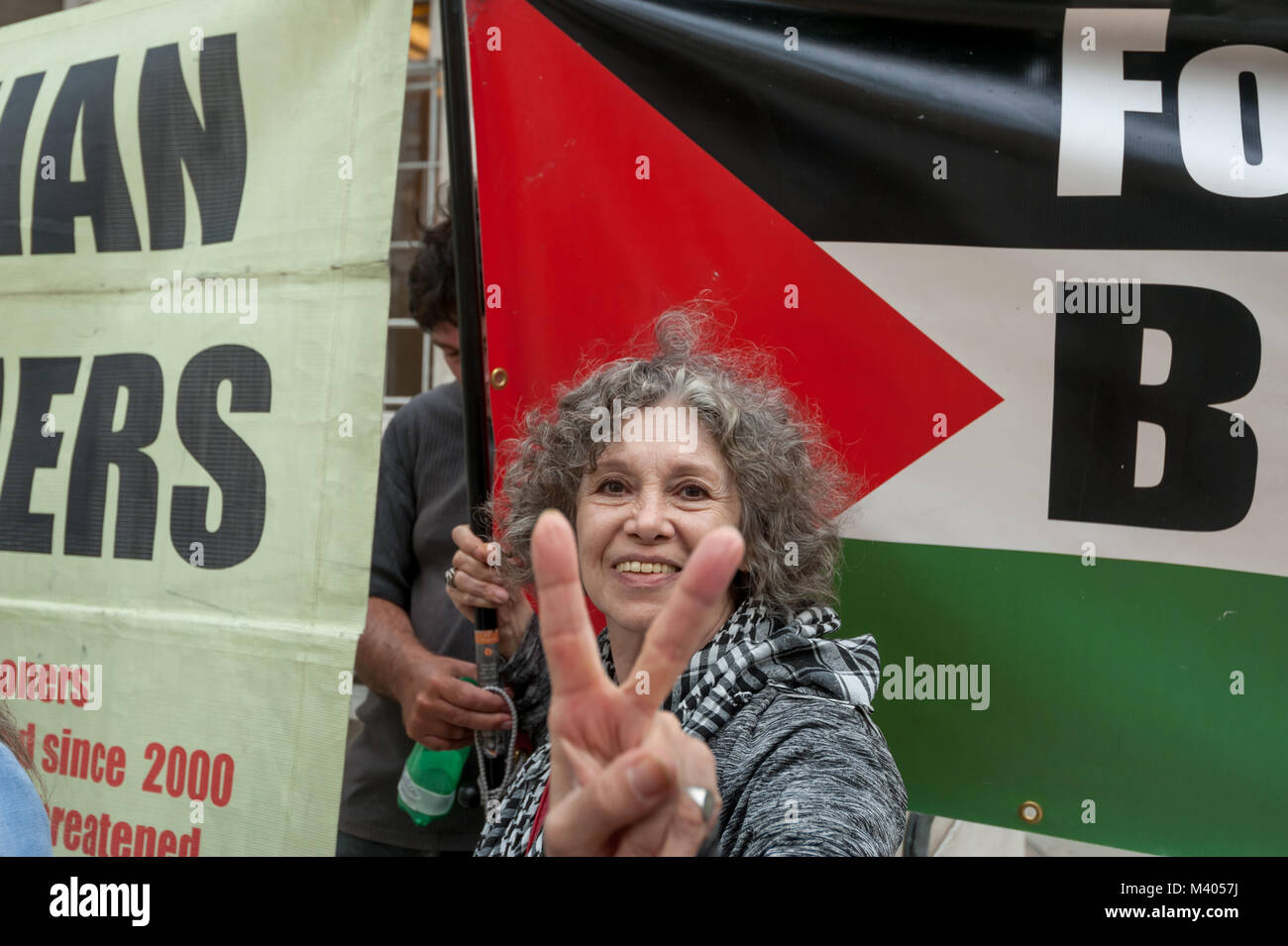 Protesters at the BBC call on it to report fairly about the illegal detention of Palestinians including the two hunger strikers. One makes a V for Victory sign for the camera. Stock Photo