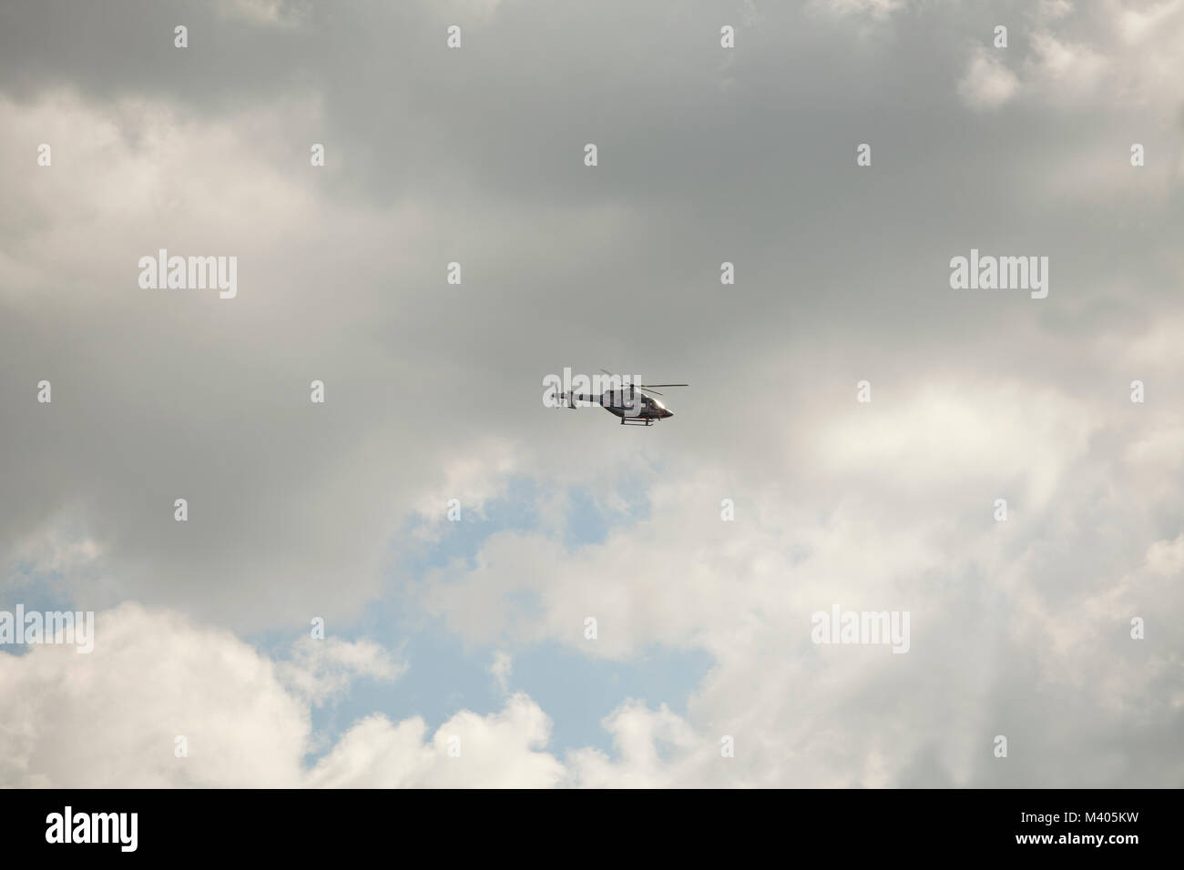 Helicopter is flying in the sky with white clouds Stock Photo - Alamy