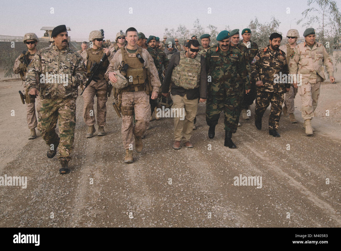 U.S. Marine Brig. Gen. Benjamin T. Watson, commanding general of Task Force Southwest (TFSW), walks with leaders of the Afghan National Defense and Security Force (ANDSF) at Camp Delaram, Afghanistan Feb. 5, 2018. Key leaders from TFSW and the ANDSF conducted a security shura to gain a greater understanding of the security situation through local elders from Nimroz province.   (U.S. Marine Corps photo by Sgt. Conner Robbins) Stock Photo