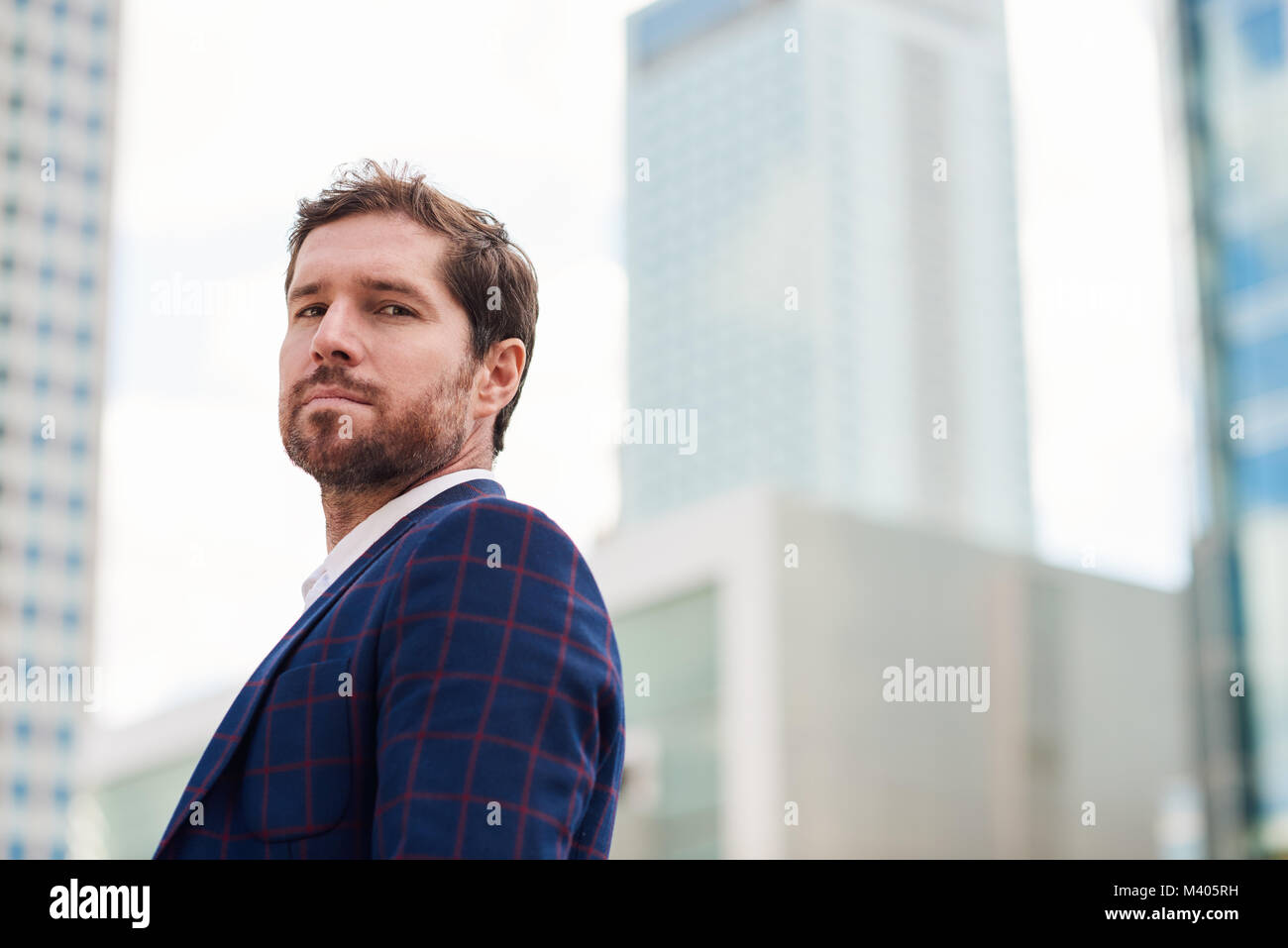 Ambitious young businessman standing alone in the city Stock Photo