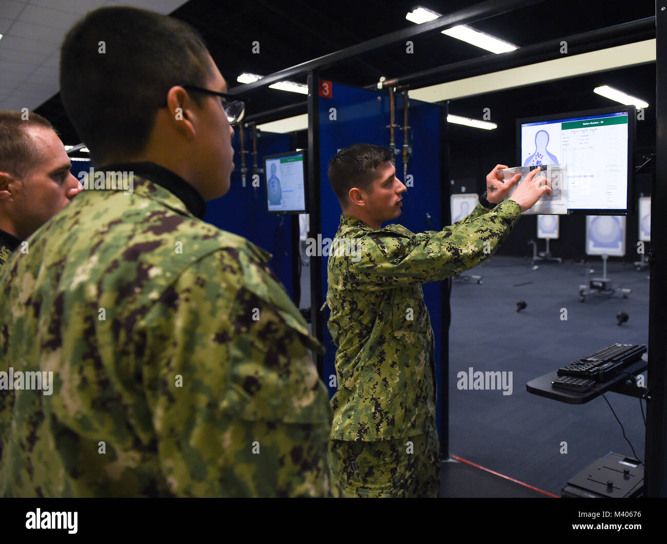 180206-N-FA012-108  GREAT LAKES, Ill (Feb. 5, 2018) Gunner’s Mate 1st Class David Tercero works with recruits after shooting at USS Missouri Simulated Arms Marksmanship Trainer (SAMT). USS Missouri is where recruits first become familiarized with firing a weapon with simulated laser-guided, air-compressed, 9-millimeter handguns and 12-gauge shotguns. About 30,000 to 40,000 recruits graduate annually from the Navy's only boot camp. (U.S. Navy photo by Mass Communication Specialist Seaman Perla Landa/Released) Stock Photo
