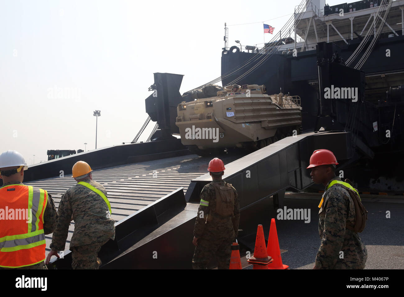 180206-N-IX266-008 LAEM CHABANG, Thailand— An amphibious assault vehicle rolls off the ramp of Military Sealift Command’s (MSC) large, medium-speed, roll-on/roll-off ship USNS Pililaau (T-AK 304) as Marines of the Offload Preparation Party observe during an offload at the port here in support of Cobra Gold 2018, Feb. 5. The USNS Pililaau is part of Maritime Prepositioning Ships Squadron THREE, which consists of a fleet of government-owned ships operated by MSC and is based in the Guam-Saipan area of the Western Pacific Ocean. CG18 is a Thailand and United States co-sponsored exercise conducted Stock Photo