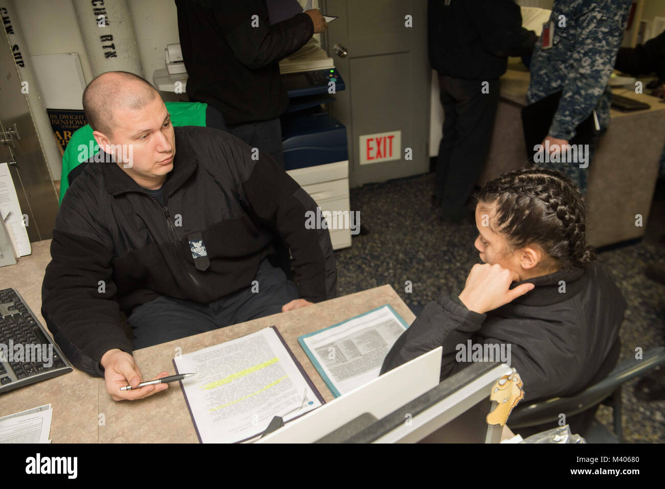 180206-N-KJ380-013  PORTSMOUTH, Va. (Feb. 6, 2017) Navy Career Counselor 1st ClassCody Wood, left, from Iona, Mich., helps Yeoman 3rd Class Jahaira Aponte, from Philadelphia, with paperwork in the career counseling office aboard the aircraft carrier USS Dwight D. Eisenhower (CVN 69)(Ike). Ike is undergoing a Planned Incremental Availability (PIA) at Norfolk Naval Shipyard during the maintenance phase of the Optimized Fleet Response Plan (OFRP). (U.S. Navy photo by Mass Communication Specialist 3rd Class Neo B. Greene III) Stock Photo