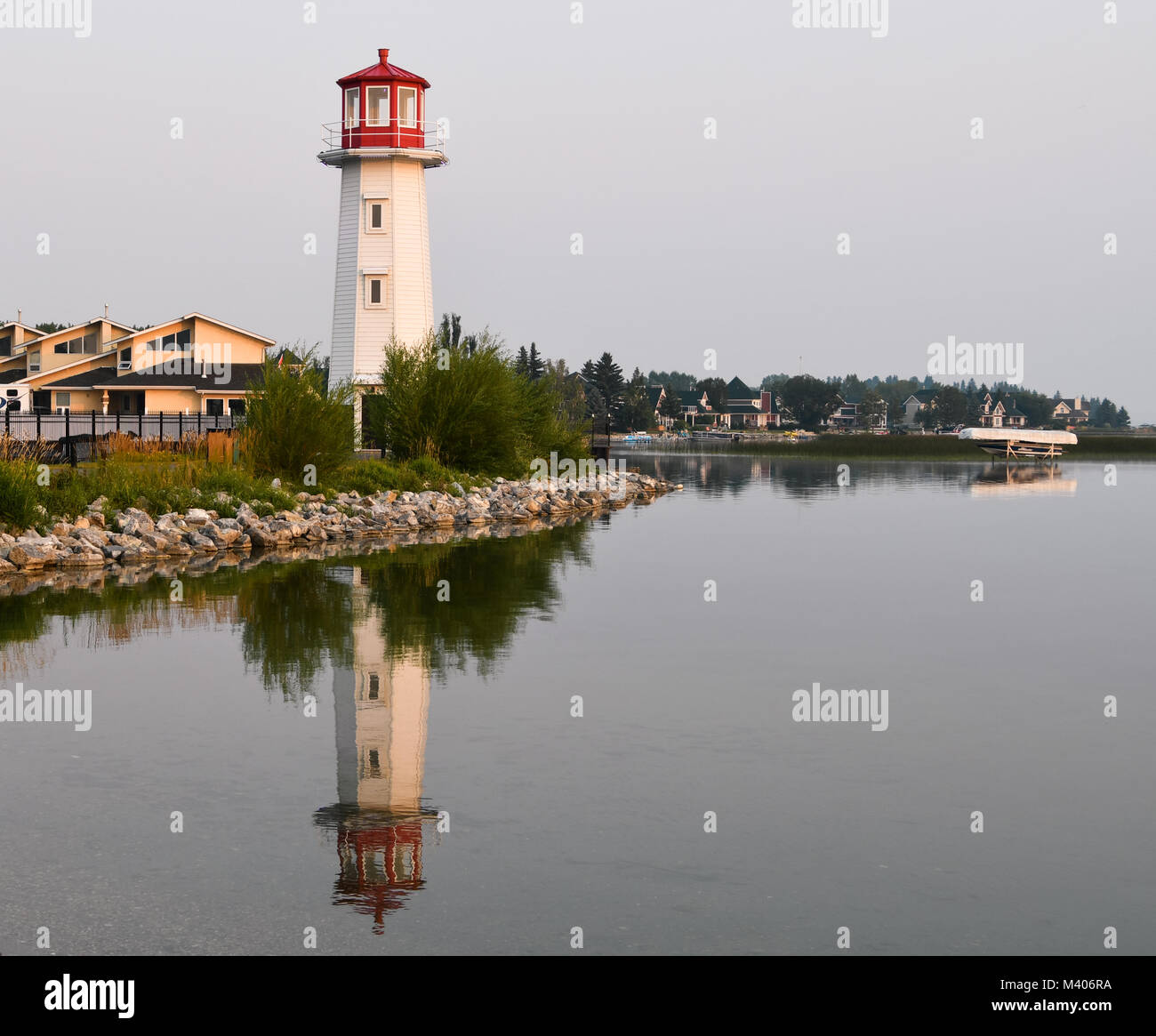 Beautiful Red and White Lighthouse with Reflections on the Water in Sylvan Lake, Alberta, Canada Stock Photo