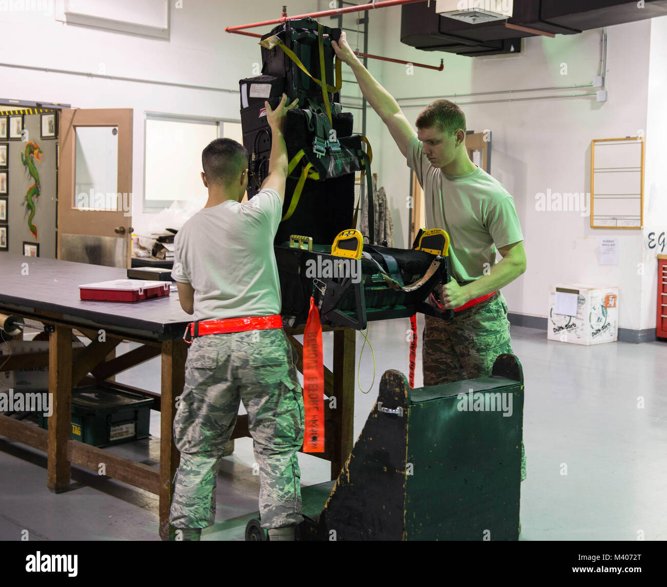 Airmen from the 18th Component Maintenance Squadron egress shop prepare to perform a visual inspection of an ejection seat Feb. 7, 2018, at Kadena Air Base, Japan. Egress is a specialized career field and requires attention to detail at all times. (U.S. Air Force photo by Senior Airman Jessica H. Smith) Stock Photo