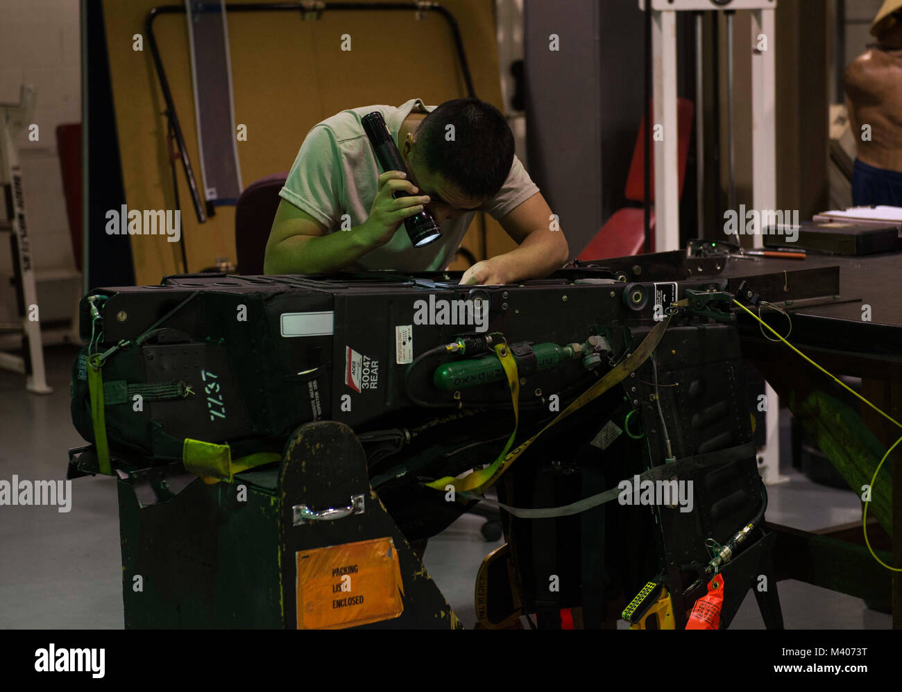 Airman 1st Class Shu Hsu, 18th Component Maintenance Squadron egress systems journeyman, performs a visual inspection on an F-15 Eagle ejection seat Feb. 7, 2018, at Kadena Air Base, Japan. Hsu enjoys the specialization of his job and takes great pride in practicing excellence with his tasks. (U.S. Air Force photo by Senior Airman Jessica H. Smith) Stock Photo