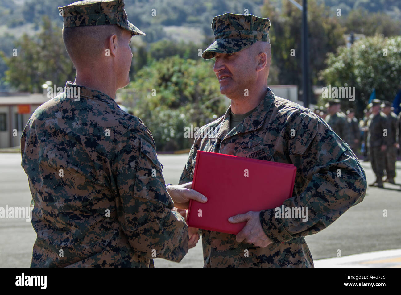 U.S. Marine Corps Col. Jeff C. Holt, the Commanding Officer for School of Infantry-West, presents Sgt. Maj. Benny R. Benton with an award during a relief and appointment ceremony, Feb. 8, 2018. The ceremony was held to appoint Sgt. Maj. Jonathan L. Groth as the new sergeant major for School of Infantry-West. (U.S. Marine Corps photo by Cpl. Andre Heath) Stock Photo