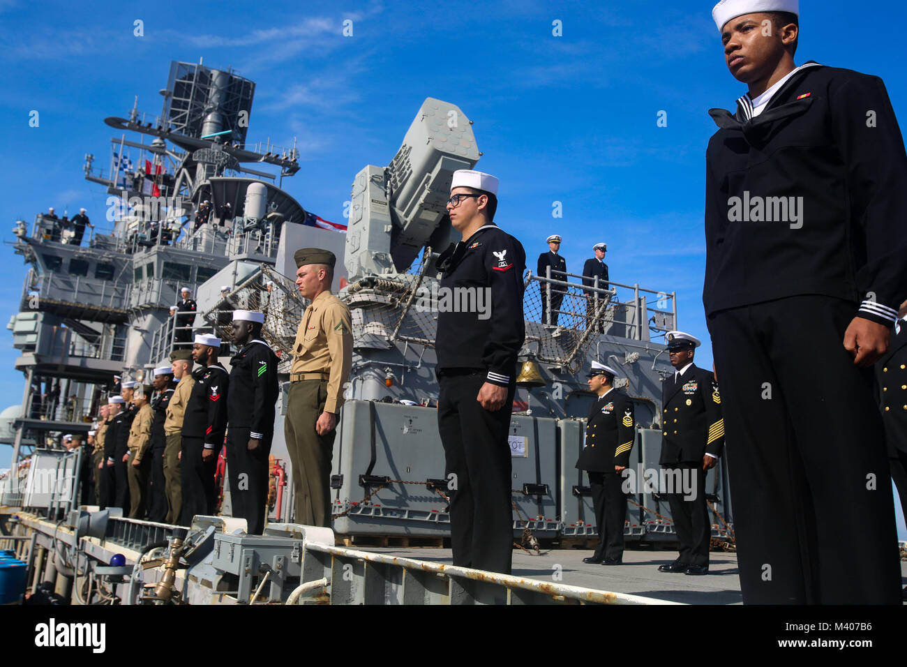 U.S. Marines and Sailors with the 26th Marine Expeditionary Unit (MEU) aboard the amphibious assault ship USS Iwo Jima (LHD 7) man the rails while departing Naval Station Mayport, Fla., Feb. 7, 2018. The 26th MEU is participating in a deployment at sea to conduct maritime and peacekeeping operations, as well as maintain relations with foreign militaries through joint exercises. (U.S. Marine Corps photo by Cpl. Jon Sosner) Stock Photo