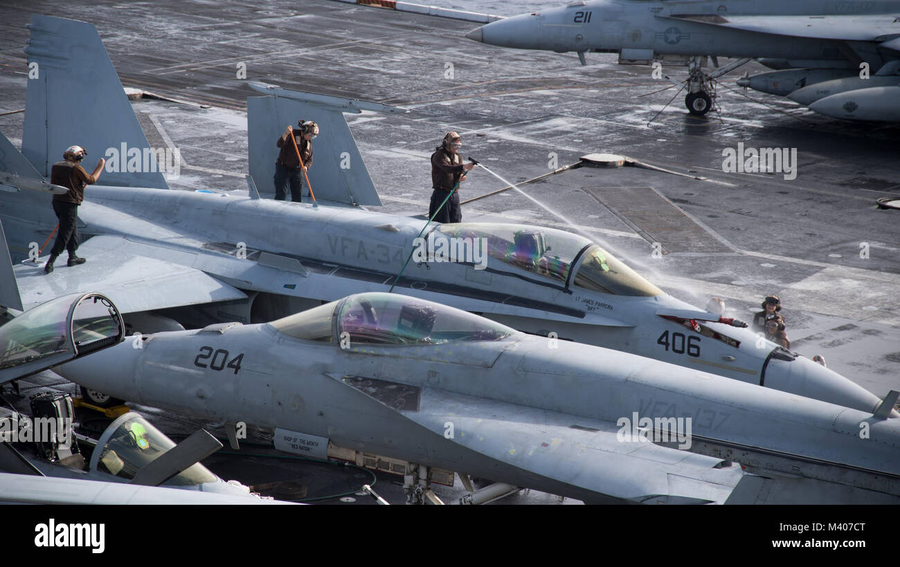 180207-N-LO978-0056  PACIFIC OCEAN (Feb. 7, 2018) Sailors wash an F/A-18C Hornet assigned to the “Blue Blasters” of Strike Fighter Squadron (VFA) 34 on the flight deck of Nimitz-class aircraft carrier USS Carl Vinson (CVN 70). Carl Vinson Strike Group is currently operating in the Pacific as part of a regularly scheduled deployment. (U.S. Navy Photo by Mass Communication Specialist 3rd Class Axxzjavon Sampson/Released) Stock Photo