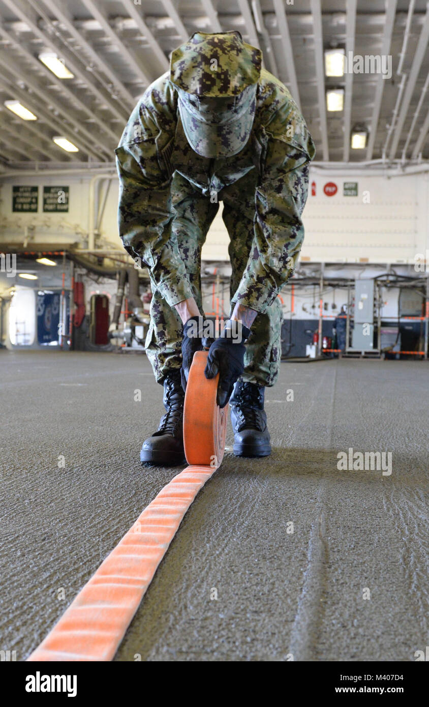 180207-NI298-135  SAN DIEGO (Feb. 7, 2018) Airman Apprentice Matthew Goho, assigned to Air department aboard amphibious assault ship USS Boxer (LHD 4), rolls up a fire hose after a hangar bay fire drill. Boxer is currently in its homeport preparing for contractor sea trials. (U.S. Navy photo by Mass Communication Specialist 3rd Class Tristin Barth/Released) Stock Photo