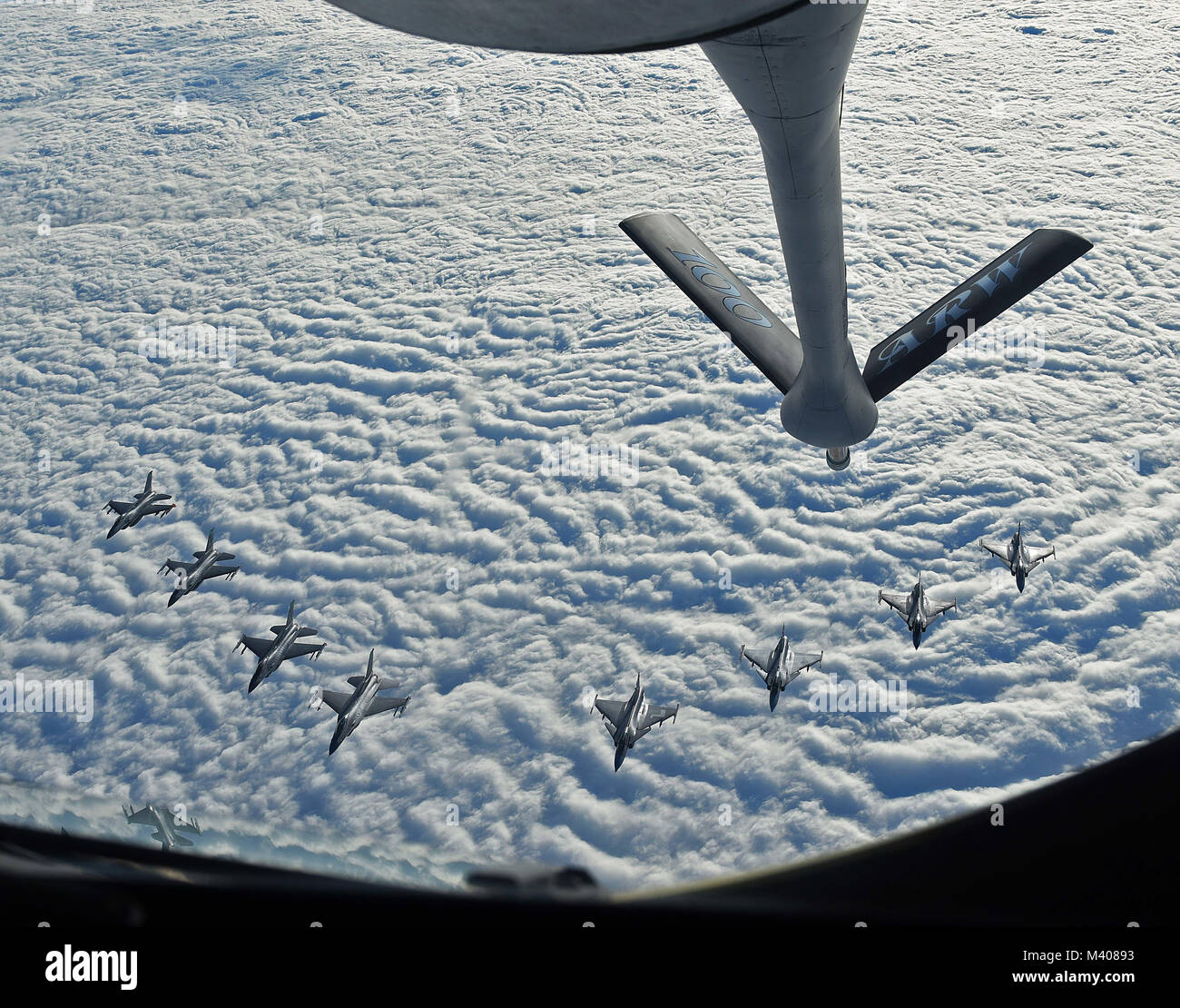 Four U.S. Air Force F-16C Fighting Falcons and four Swedish Air Force JAS 39 Gripens fly in formation together behind a U.S. Air Force KC-135 Stratotanker during aerial refueling training in Swedish airspace, Feb. 8, 2018. The air refueling training is in conjunction with a rotational deployment of F-16Cs from the Ohio Air National Guard’s 180th Fighter Wing to Amari Air Base, Estonia, as part of a Theater Security Package. The training allows the U.S. and Sweden to strengthen interoperability and increase readiness.  (U.S. Air Force photo by Airman 1st Class Luke Milano) Stock Photo
